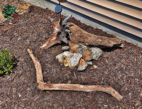 The beginnings of Stone-Breath, built from weathered branches and stones in a garden bed